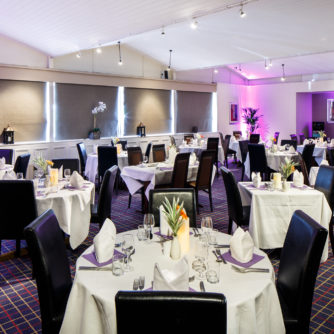 The Brasserie restaurant at Mercure Wetherby Hotel, purple lighting, orange flowers on the tables