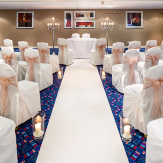 The Wharfedale Suite at Mercure Wetherby Hotel, set up for a wedding ceremony, white aisle, white chair covers